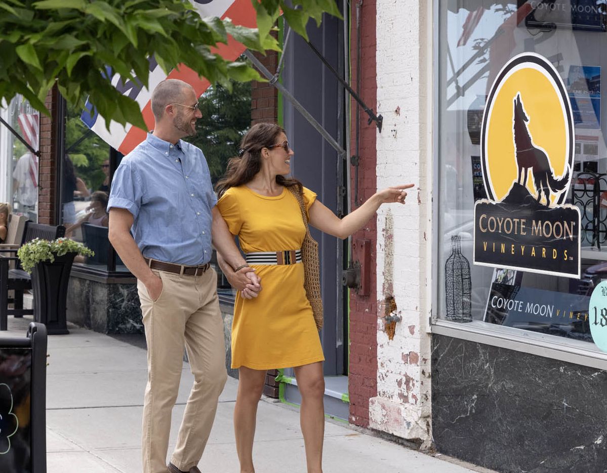 A couple walking in downtown Clayton NY exploring a wine tasting