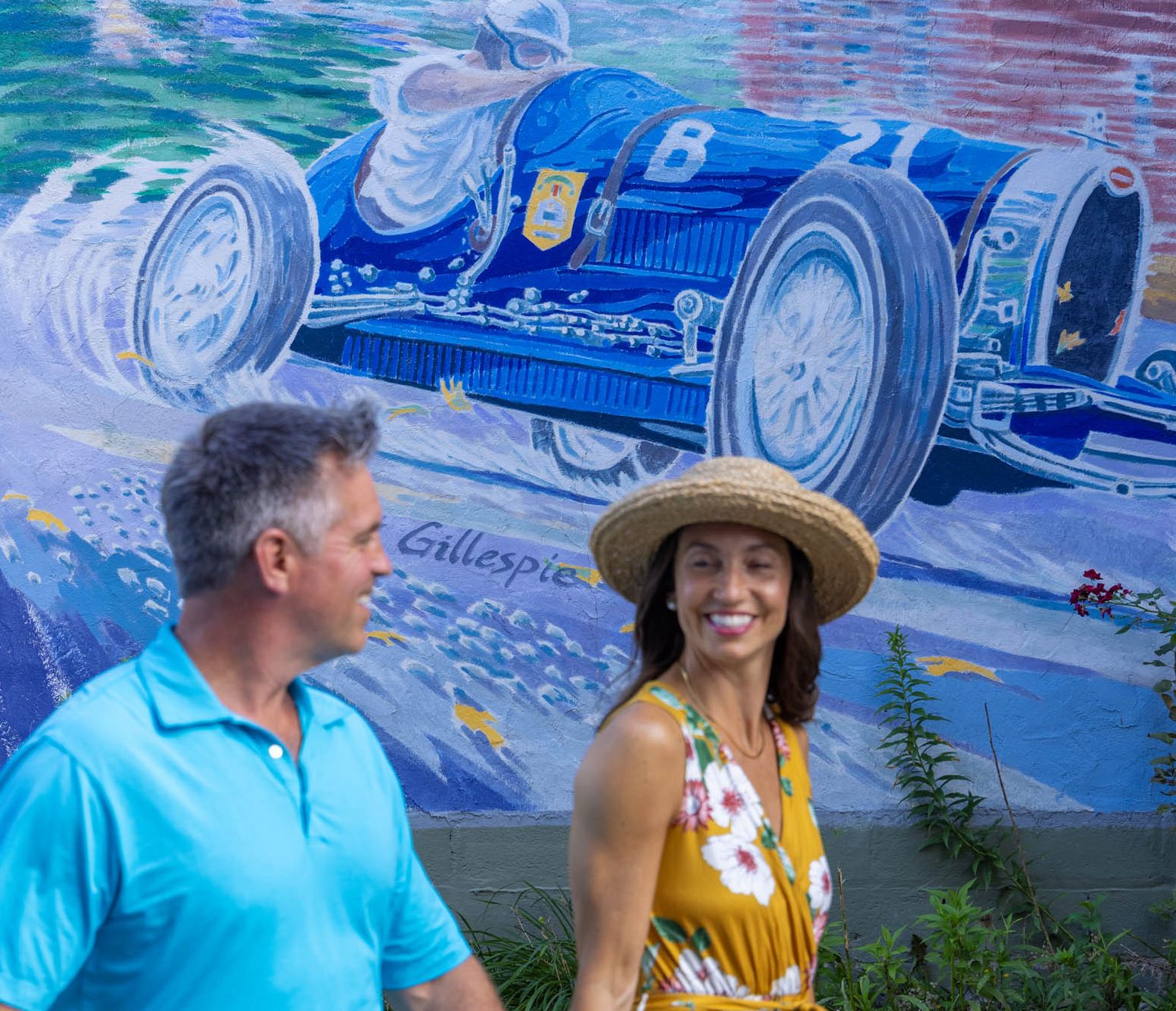 A couple walks past one of many racing-themed murals in downtown Watkins Glen